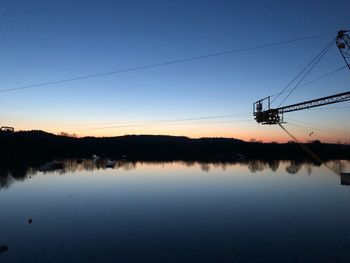 Crane over lake during sunset