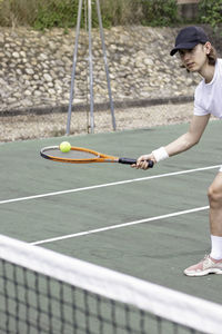 Croped view of young sportsman playing tennis hitting the tennis ball with the racket movement image
