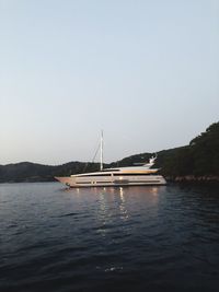 Sailboat sailing on sea against clear sky