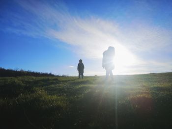 Silhouette man standing on field against sky