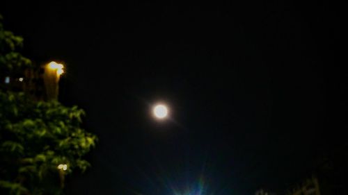 Low angle view of illuminated moon against clear sky at night