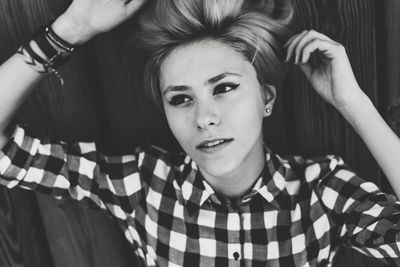 High angle view of young woman lying down on wood