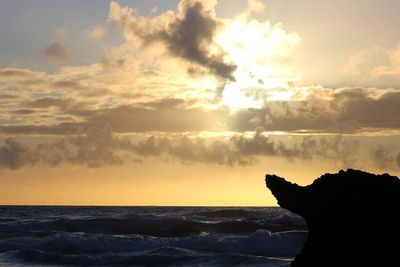 Scenic view of sea against dramatic sky during sunset