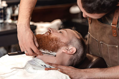 Midsection of barber grooming customer