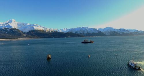 Scenic view of sea and mountains against clear sky