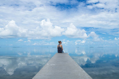 Rear view of woman looking at sea against sky