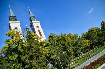 Low angle view of trees and building against sky