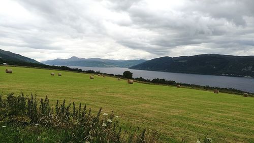 Scenic view of sea and mountains against dramatic sky