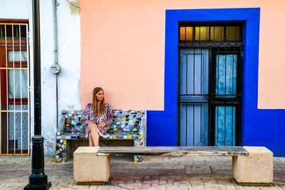 Young woman sitting outside building