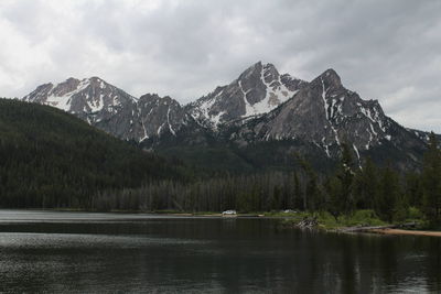 Scenic view of mountains and lake against cloudy sky