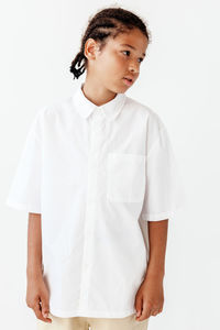 Portrait of young man standing against white background