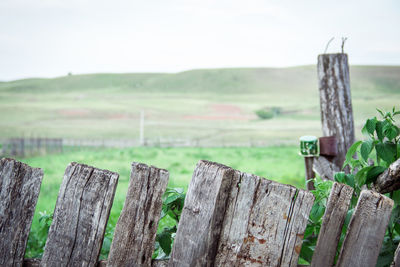 Wooden fence on field against sky