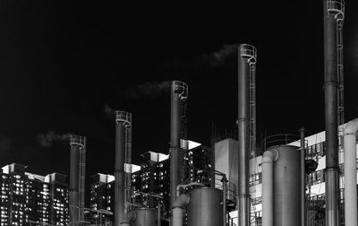 Low angle view of smoke stack against sky at night