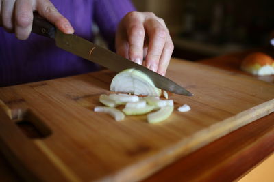 Cropped hand of person preparing food on table