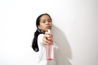 Portrait of a smiling young woman against white background