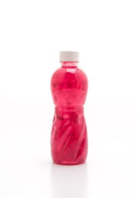 Close-up of pink bottle against white background