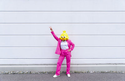 Portrait of girl standing against pink wall