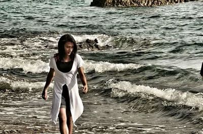 Portrait of smiling young woman standing at beach