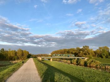 Road by trees against sky