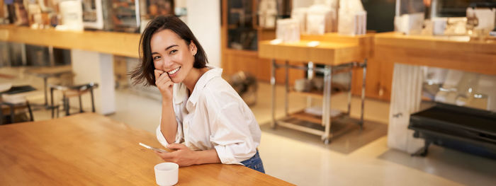 Portrait of young woman standing on table