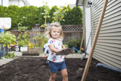 Young girl helping with a landscaping project in her backyard.