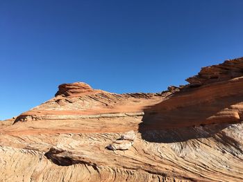 Scenic view of desert against clear blue sky