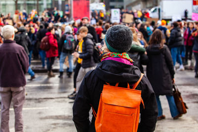 Rear view of people walking on city street