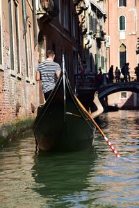 Rear view of man on gondola sailing in canal