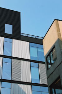 Low angle view of modern building against clear blue sky