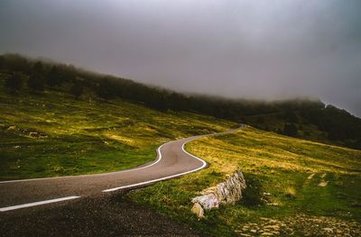 Scenic view of road by mountain against sky