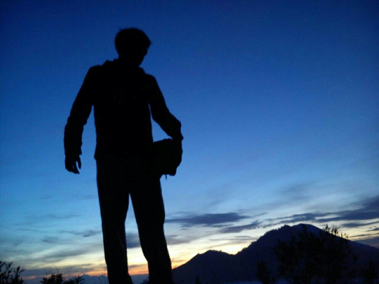 silhouette, standing, leisure activity, lifestyles, sky, men, low angle view, full length, blue, tranquility, tranquil scene, mountain, nature, scenics, beauty in nature, cloud - sky, three quarter length, rear view