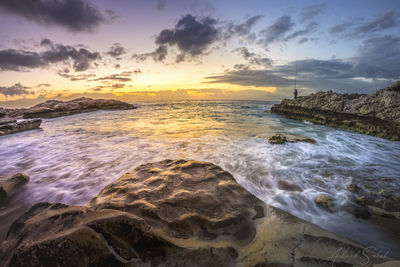 Scenic view of fisherman sea against sky during sunset