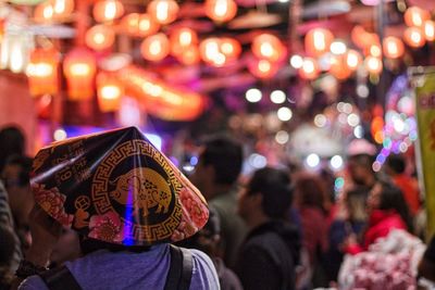 Rear view of people against illuminated city at night