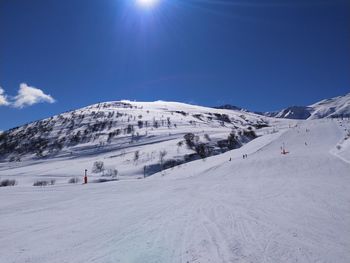 Scenic view of snowcapped mountains against blue sky