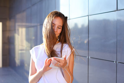 Portrait of young woman standing by window