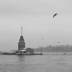 Maiden tower amidst sea against sky