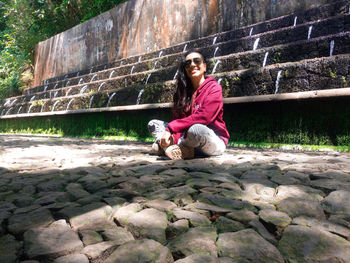 Portrait of woman with dog sitting outdoors