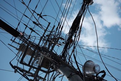 Low angle view of power lines against blue sky