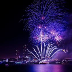 Firework display over river at night