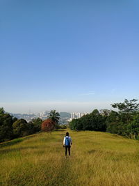 Rear view of man on field against sky