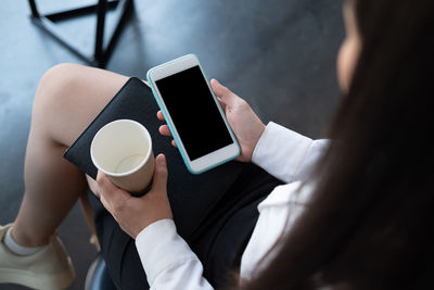 Midsection of man holding coffee cup