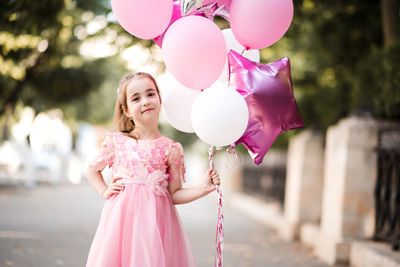 Portrait of woman holding heart shape balloons