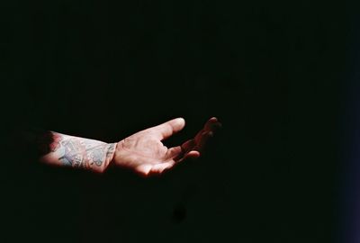 Cropped image of hand holding over black background