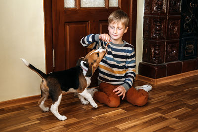 Woman with dog sitting on wooden floor