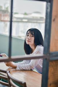 Portrait of a young woman sitting on table