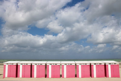 Low angle view of hooded beach chairs against sky