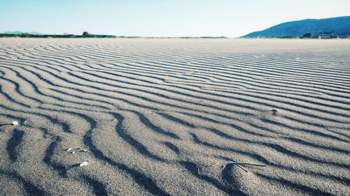 Sand dunes at beach against sky