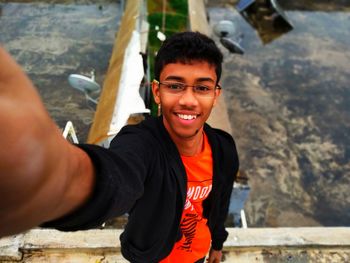 High angle portrait of teenage boy taking selfie on terrace