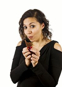 Portrait of young woman holding hair over white background