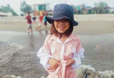 Full length of young woman wearing hat standing on land